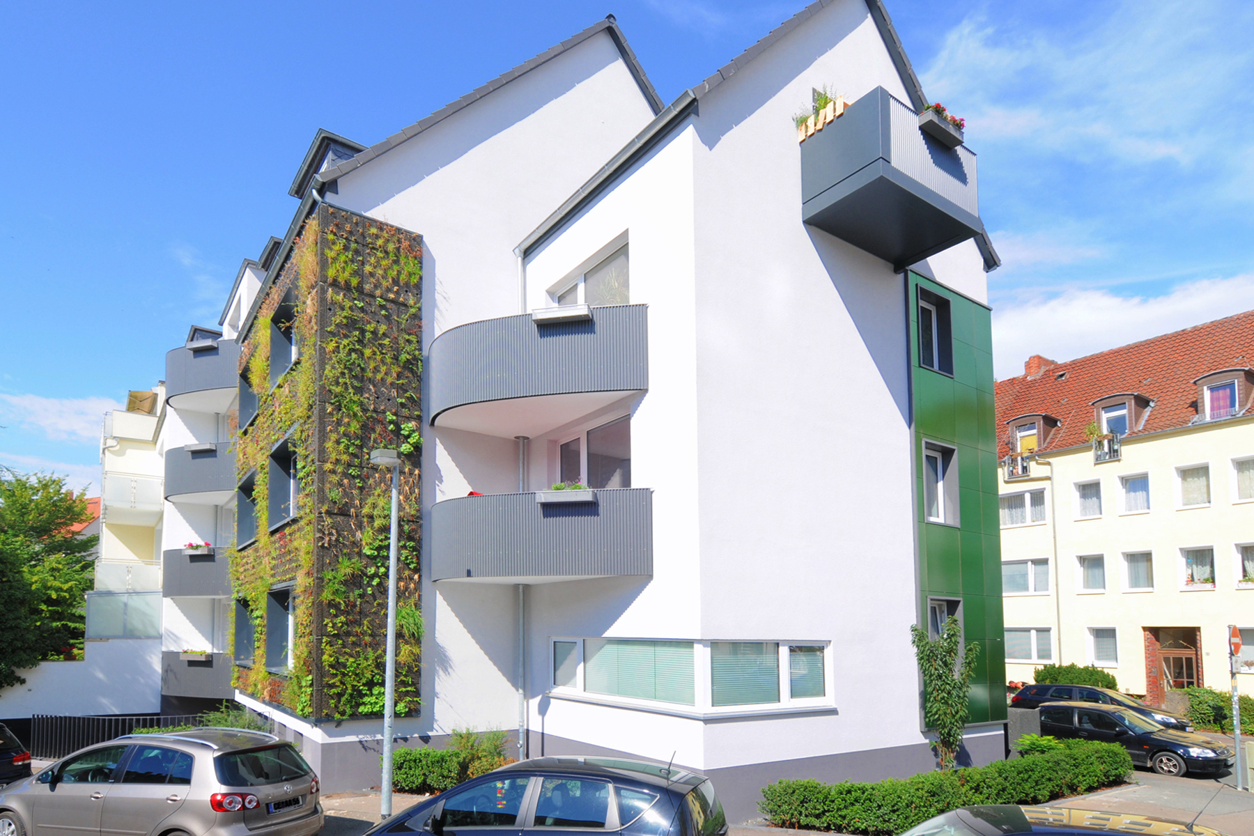 Fassadensanierung Hannover: Gundlach saniert eine Fassade nach nachhaltigen Standard. Auf dem Bild ist Fassadenbegrünung und neue Balkone zu sehen.